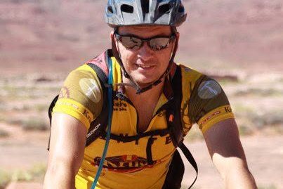 Daniel racing a mountain bike in full kit, mid-effort